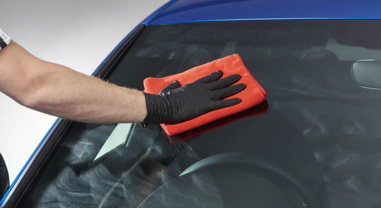 man polishing a car windshield