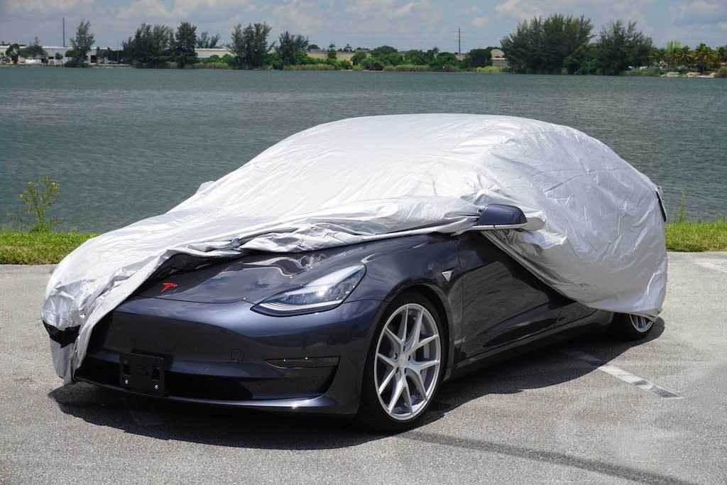 car cover half covering a tesla