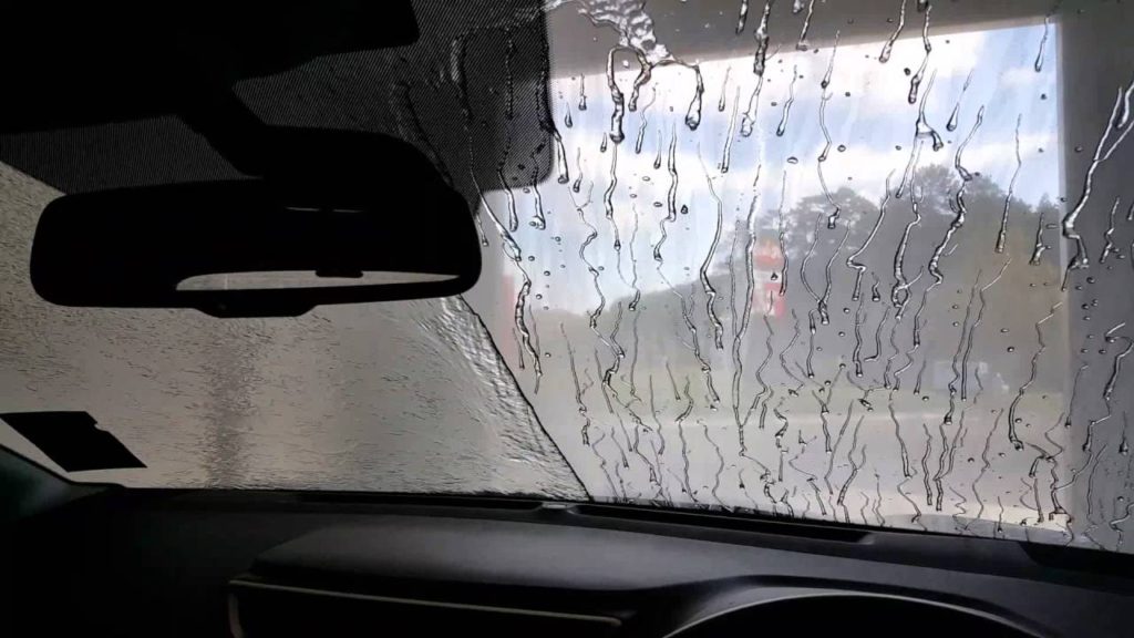 demonstration of a windshield where one side has glass sealant applied and one side does not